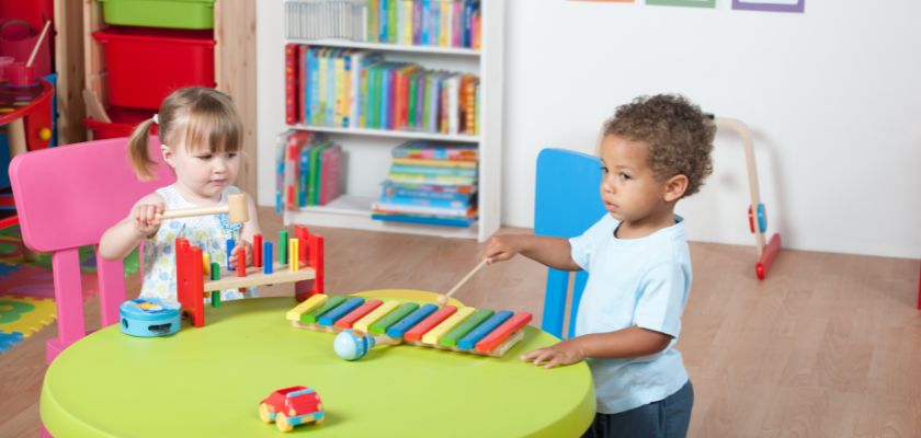 Otroci se igrajo z lesenimi igračami na mizi